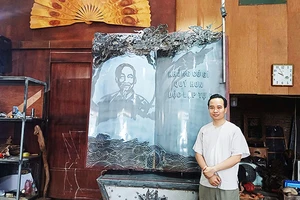 Nghệ nhân Bùi Minh Tự bên tác phẩm “Trang sử vàng”.