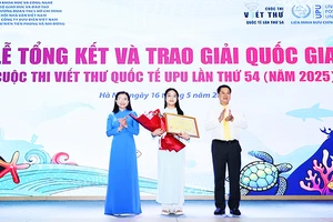 Minh Khuê (đứng giữa) nhận bằng khen và hoa trong lễ tổng kết và trao giải.