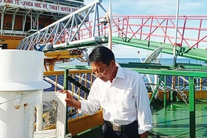 Anh Phan Thành Thật, quan trắc viên khí tượng Trạm Khí tượng thủy văn DK1/7, đang kiểm tra thiết bị đo khí tượng thủy văn.