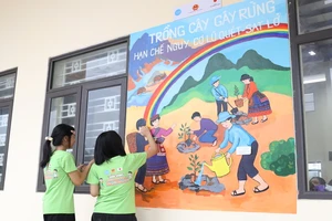 Các em học sinh Trường phổ thông dân tộc nội trú Trung học cơ sở và Trung học phổ thông huyện Bảo Thắng, tỉnh Lào Cai vẽ tranh tường.