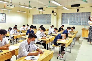 Giám thị hướng dẫn cách làm bài thi môn Toán tại điểm thi Trường THPT Nguyễn Gia Thiều, thành phố Hà Nội. (Ảnh: MỸ HÀ)