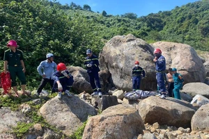 Lực lượng chức năng đưa thi thể được phát hiện dưới ghềnh đá trên bán đảo Sơn Trà lên phía trên. (Ảnh: Công an cung cấp) 