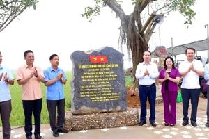 Các đại biểu gắn biển công trình nơi Bác Hồ về thăm tại cánh đồng Chằm, xã Khánh Cư, huyện Yên Khánh. (Ảnh: ĐỨC LAM)