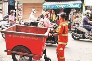 Công nhân vệ sinh thu gom và vận chuyển rác thải ở Quận 1.