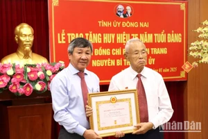 Phó Bí thư Thường trực Tỉnh ủy Đồng Nai Hồ Thanh Sơn trao Huy hiệu 75 năm tuổi đảng cho đồng chí Phan Văn Trang.