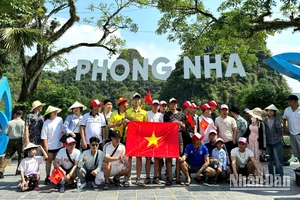 Du khách chụp ảnh lưu niệm trước khi xuống thuyền tham quan động Phong Nha và động Tiên Sơn.