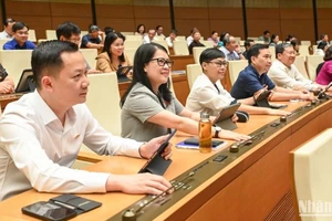 Các đại biểu Quốc hội biểu quyết thông qua Nghị quyết của Quốc hội về thí điểm về một số cơ chế, chính sách đặc thù phát triển nhà ở xã hội. (Ảnh: BÙI GIANG)