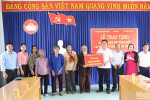 Đại diện Báo Nhân Dân trao bảng tượng trưng số tiền 250 triệu đồng tặng 5 gia đình, mỗi gia đình 50 triệu đồng để xây dựng nhà đại đoàn kết.