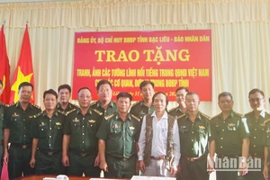 Trao tặng bộ tranh của Báo Nhân Dân về các vị tướng tài dành cho cán bộ, chiến sĩ Bộ Chỉ huy Bộ đội Biên phòng tỉnh Bạc Liêu. (Ảnh: PHAN TRỌNG VĨNH)