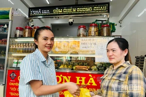 Hộ gia đình chị Phạm Tuyết Linh (bên trái), cơ sở sản xuất bánh mì và chả lụa Sơn Hà nổi tiếng hơn 40 năm qua tại Bạc Liêu ký cam kết với cơ quan chức năng thực hiện nghiêm các biện pháp an toàn thực phẩm trong dịp Tết. (Ảnh: TRỌNG DUY)