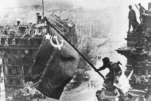 Một chiến sĩ Hồng quân Liên Xô phất cờ mừng chiến thắng tại Berlin. Ảnh tư liệu