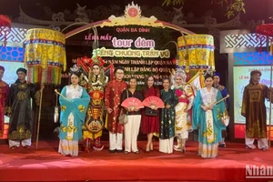 Du khách chụp ảnh lưu niệm với các diễn viên sau khi trải nghiệm tour đêm “Tiếng chuông Trấn Vũ”.
