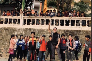 Tình nguyện viên Lê Bá Ngọc và các em học sinh Trường tiểu học xã Cán Cấu (Simacai, Lào Cai) Ảnh: Bá Bá