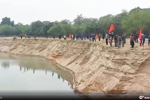 Người dân xã Đồng Văn, huyện Thanh Chương tập trung bên bờ sông Lam, dựng lán, đánh trống… để phản đối hoạt động khai thác cát, sỏi của Công ty cổ phần Khai thác cát, sạn và Vận tải Thanh Chương. (Ảnh cắt từ video clip)