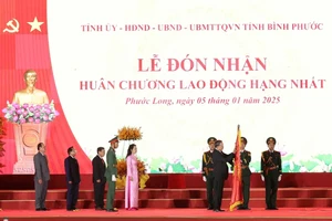 Tổng Bí thư Tô Lâm trao tặng Huân chương Lao động hạng Nhất cho Đảng bộ, chính quyền và nhân dân thị xã Phước Long. (Ảnh: TTXVN)