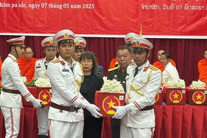 Các đại biểu thực hiện nghi lễ tiễn đưa hài cốt các liệt sĩ về nước. (Ảnh: HẢI TIẾN)