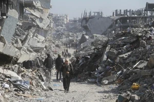 Người dân Palestine trên một con phố có những tòa nhà bị phá hủy tại trại tị nạn Jabalia ở phía bắc Dải Gaza, vào ngày 29/1/2025. (Ảnh: Tân Hoa xã)