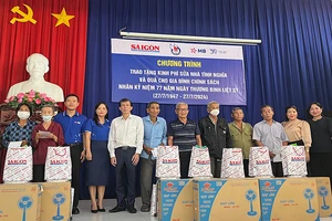 Đại diện Báo Sài Gòn Giải Phóng tặng quà các gia đình chính sách, gia đình có công với cách mạng ở xã Thanh Phước.