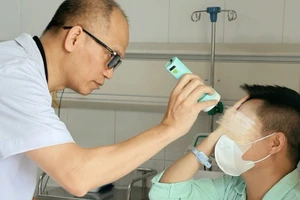 Phó Giáo sư, Tiến sĩ Nguyễn Hồng Hà -Trưởng Khoa Phẫu thuật Hàm mặt, Tạo hình và Thẩm mỹ khám cho bệnh nhân.