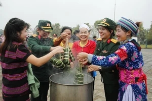 Đồng bào các dân tộc đang hoạt động tại "Làng" cùng các chiến sĩ tham gia luộc bánh chưng. (Ảnh: PH)