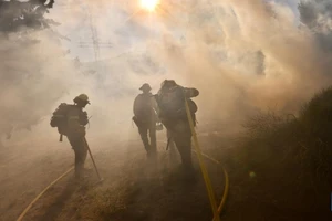 Lính cứu hỏa làm việc tại hiện trường vụ cháy Post Fire ở Gorman, cách Los Angeles, khoảng 100 km về phía bắc. (Ảnh: Tân Hoa xã)