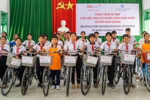 Các học sinh nghèo hiếu học tại huyện Nam Giang nhận xe đạp do Tổ chức phi Chính phủ Lifestart Foundation trao tặng. (Ảnh: ĐÌNH TĂNG)