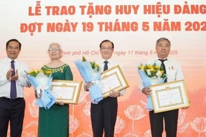 Chủ tịch Ủy ban nhân dân Thành phố Hồ Chí Minh Nguyễn Văn Được trao Huy hiệu 45 năm tuổi đảng cho các đảng viên. (Ảnh: LÊ VĨNH)