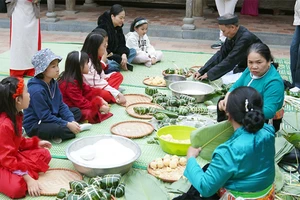 Các em nhỏ được trải nghiệm gói bánh chưng tại Bảo tàng Dân tộc học Việt Nam.