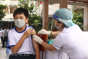 Nhân viên y tế tiêm vaccine cho học sinh lớp 6 tại Trường THCS Lê Quý Đôn, thành phố Vĩnh Long. (Ảnh: TTXVN)