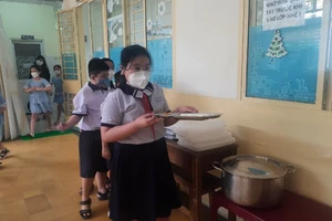 Học sinh Trường tiểu học Phan Đình Phùng, quận 3 trong giờ ăn bán trú. (Ảnh mang tính chất minh họa)