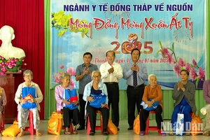 Lãnh đạo ngành Y tế Đồng Tháp và huyện Tháp Mười trao quà cho các hộ gia đình có công với ngành y tế. (Ảnh: HOÀNG KHA)