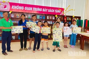 Ông Trần Tuấn Khanh, Phó Trưởng phòng Công tác người đọc, Thư viện tỉnh Đồng Tháp, tặng phụ trương đến bạn đọc trẻ. (Ảnh: Thư viện tỉnh Đồng Tháp)