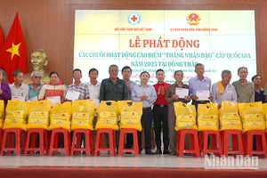 Đại diện 20 hộ gia đình chính sách có hoàn cảnh khó khăn ở huyện Tân Hồng nhận quà với mỗi suất 2 triệu đồng tiền mặt. (Ảnh: HỮU NGHĨA)