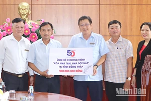 Phó Chủ tịch Ủy ban Mặt trận Tổ quốc Việt Nam tỉnh Đồng Tháp Võ Chí Hữu (thứ hai từ trái sang) tiếp nhận số tiền ủng hộ của đơn vị tài trợ. (Ảnh: NHƯ ANH)