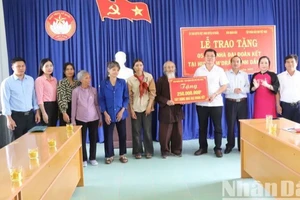 Đại diện Báo Nhân Dân trao bảng tượng trưng số tiền 250 triệu đồng tặng 5 gia đình, mỗi gia đình 50 triệu đồng để xây dựng nhà đại đoàn kết.