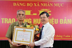 Đồng chí Nguyễn Văn Sơn, Phó Bí thư Tỉnh ủy, Chủ tịch Ủy ban nhân dân tỉnh Tuyên Quang trao Huy hiệu 75 tuổi Đảng cho đảng viên Lương Minh Thủ, chi bộ thôn Kai Con, Đảng bộ xã Nhân Mục, huyện Hàm Yên.