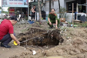 Lực lượng Công an xã Tân Thanh kiểm tra độ rộng của hố sụt lún.
