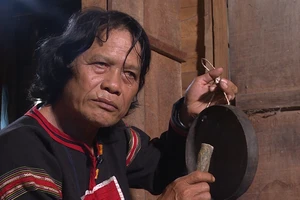 Nghệ nhân Nay Phai đang thử độ ngân khi chỉnh chiêng. (Ảnh: NX)