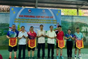 Ban tổ chức trao cờ lưu niệm cho các đội tham dự giải.