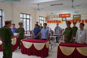 Cơ quan cảnh sát điều tra thi hành quyết định khởi tố đối với hai lãnh đạo xã Yến Dương. (Ảnh: THUỲ DƯƠNG).