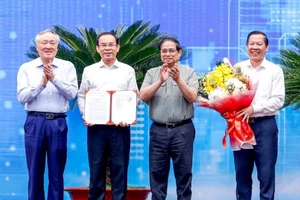 Thủ tướng Phạm Minh Chính và Phó Thủ tướng Thường trực Chính phủ Nguyễn Hòa Bình chúc mừng lãnh đạo Thành phố Hồ Chí Minh nhận Quyết định của Thủ tướng Chính phủ phê duyệt Quy hoạch Thành phố (Ảnh: THANH GIANG). 