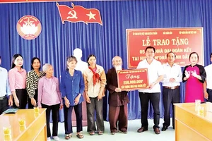 Đại diện Báo Nhân Dân trao bảng tượng trưng số tiền 250 triệu đồng tặng 5 gia đình ở huyện M’Drắk xây nhà Đại đoàn kết.