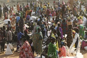 Người dân xếp hàng chờ nhận hàng cứu trợ tại Gedaref, Sudan. (Ảnh: AFP/TTXVN)