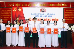 Trưởng Ban Tuyên giáo Thành ủy Hà Nội Nguyễn Doãn Toản và Bí thư Quận ủy Long Biên Đường Hoài Nam trao Quyết định kết nạp đảng viên.