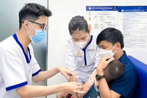 Nhiều phụ huynh đưa trẻ đi tiêm vắc xin sởi.