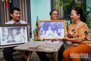 Ông Hồ Ngọc Biên (ở giữa) cùng vợ và người con trai thứ 2 bên những tấm hình vinh dự được chụp chung với Bác Hồ.