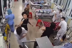 Thanh niên áo đen dùng tay đánh điều dưỡng viên Nguyễn Văn H. (Ảnh cắt từ video clip). 