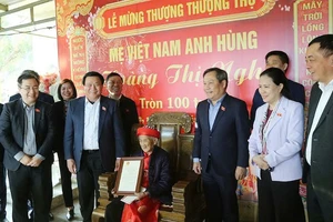 Đồng chí Nguyễn Xuân Thắng trao thiếp mừng thọ tròn 100 tuổi của Chủ tịch nước cho Mẹ Việt Nam Anh hùng Hoàng Thị Nghi.