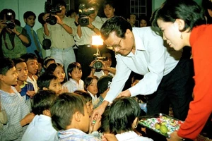 Chủ tịch nước Trần Đức Lương vui tết Trung thu và tặng quà cho các cháu có hoàn cảnh khó khăn, mồ côi được nuôi dậy tại các cơ sở mái ấm tình thương ở các quận, huyện của thành phố Hà Nội ngày 5/10/1998. (Ảnh: Trọng Nghiệp/TTXVN)