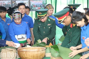 Đại tá Đỗ Quang Thấm, Bí thư Đảng ủy, Chính ủy Bộ đội Biên phòng tỉnh Đắk Lắk tham gia gói bánh chưng tại chương trình tặng nhân dân biên giới đón Tết.